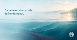 Soft teal and pale blue abstract forms showing a calm surface with quiet stillness beneath it, representing functional freeze in high-functioning adults.